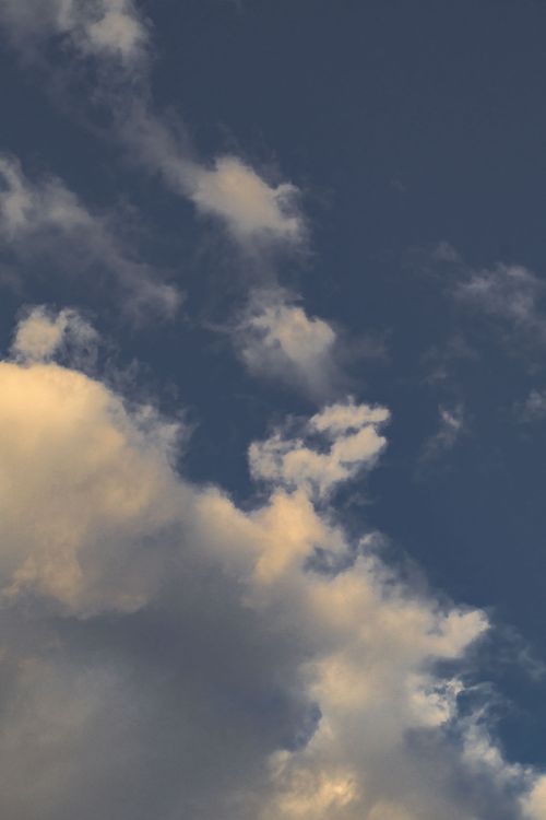 Free Soft and serene clouds during a warm sunset, perfect for calming backgrounds. Stock Photo