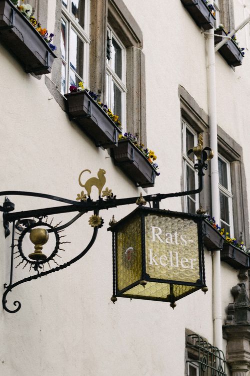 Free Elegant Ratskeller sign on a historic building facade with flower-adorned windows. Stock Photo