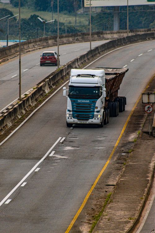 Free White truck driving on a highway in Mankayane, showcasing transportation infrastructure. Stock Photo