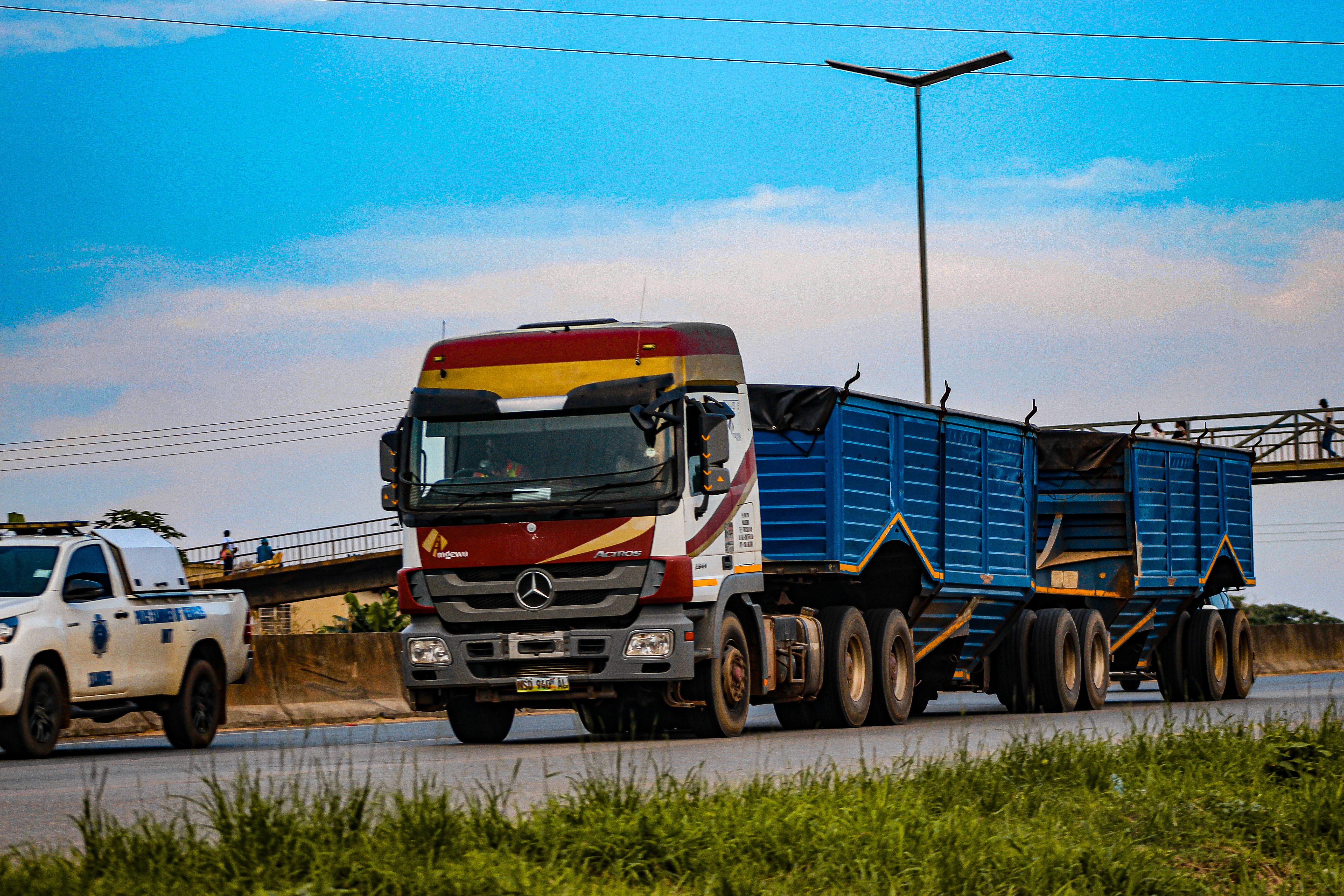 A large commercial truck drives on a highway in Mankayane, Eswatini during the day.