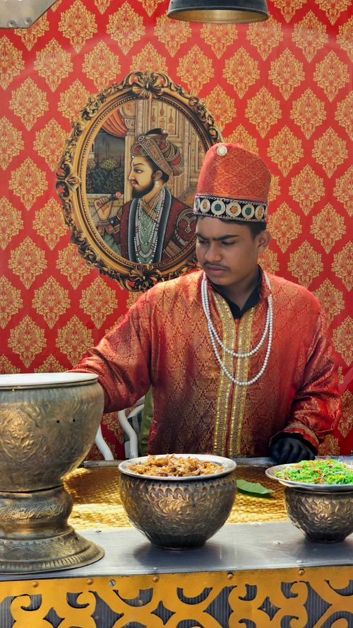 Free A chef dressed in traditional attire prepares Indian cuisine at a cultural event. Stock Photo