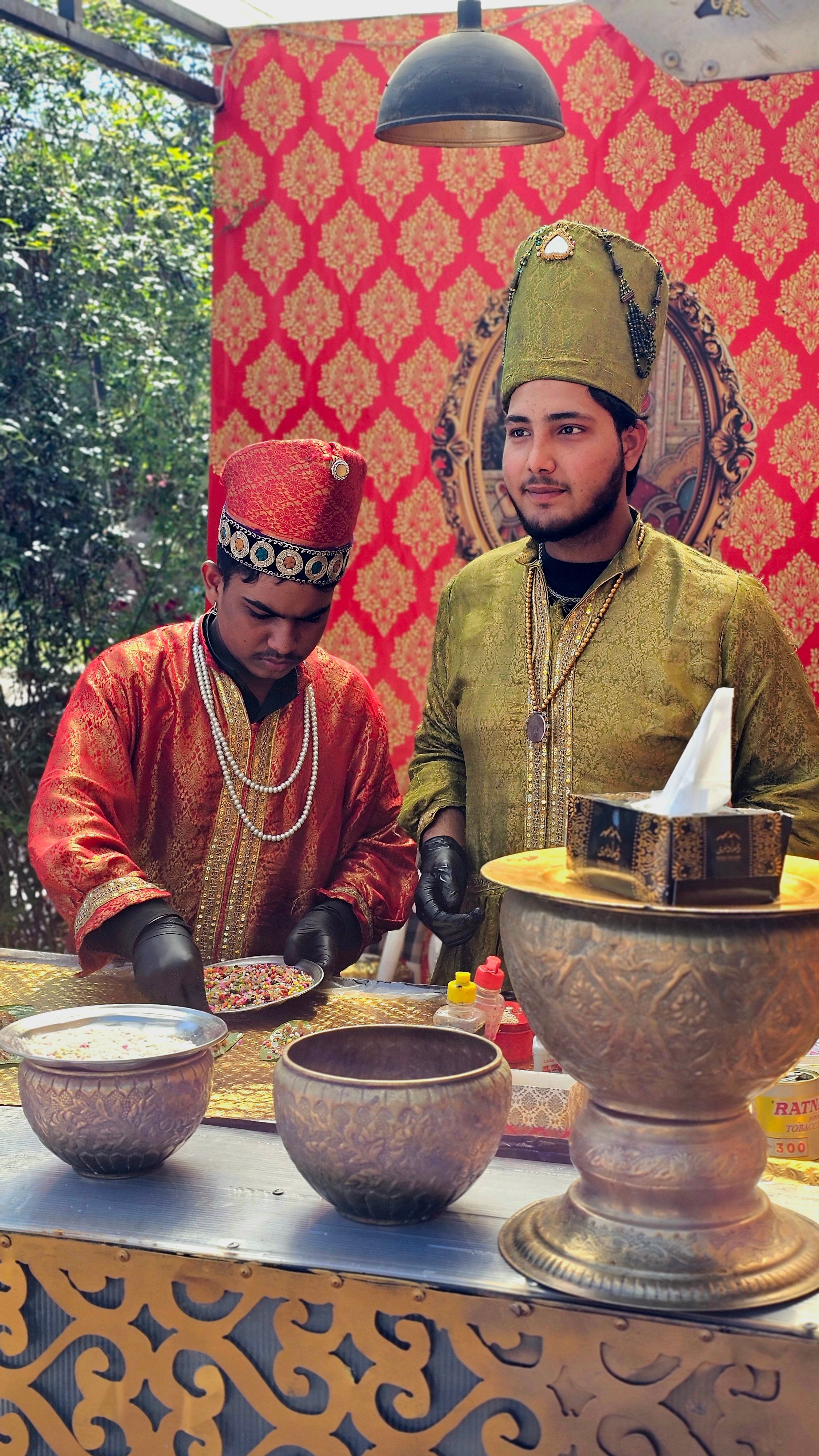 Vibrant street scene with vendors in traditional attire preparing local cuisine.