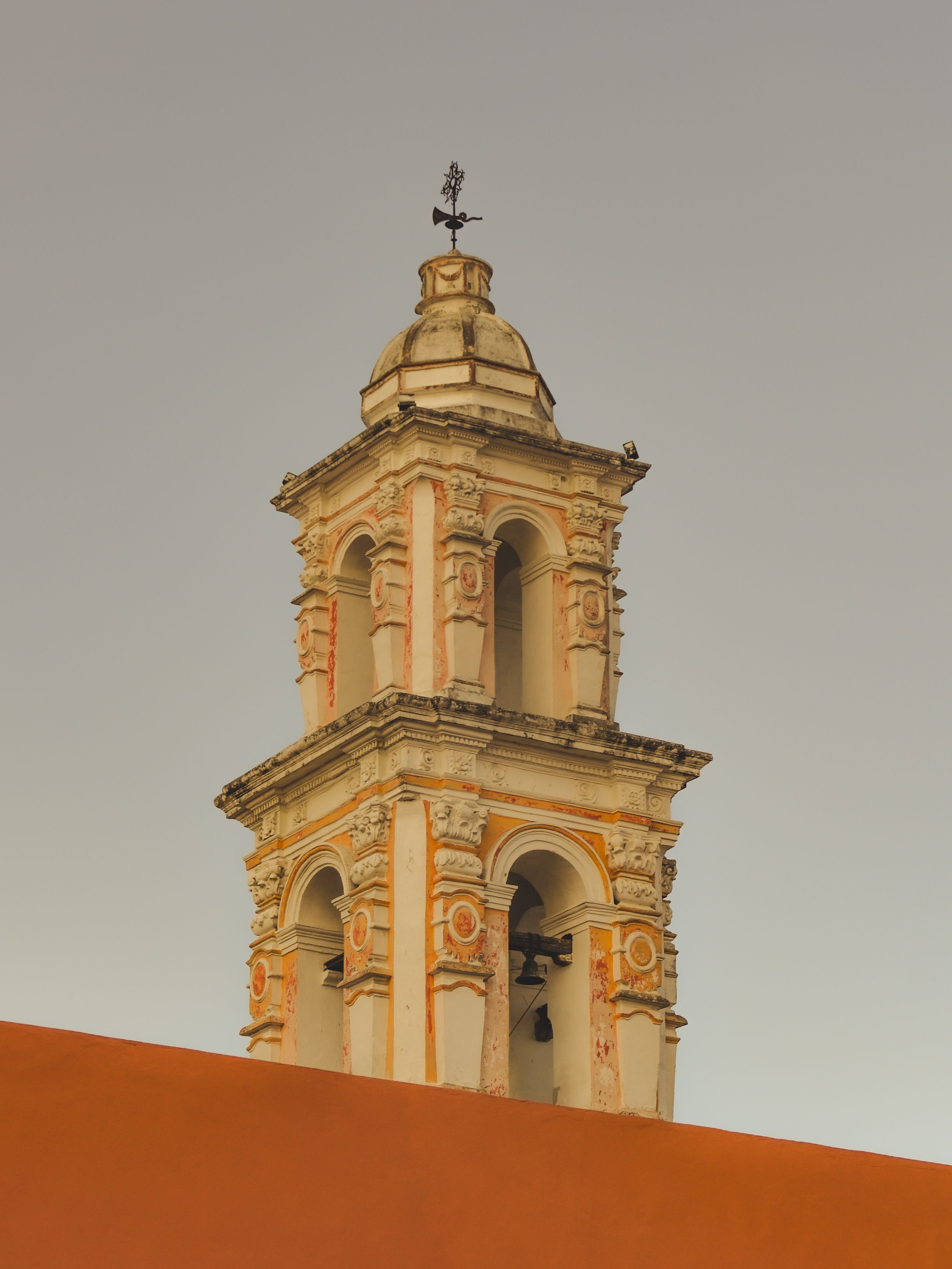 A classic bell tower against a clear sky in Puebla, Mexico showcasing Spanish colonial architecture.