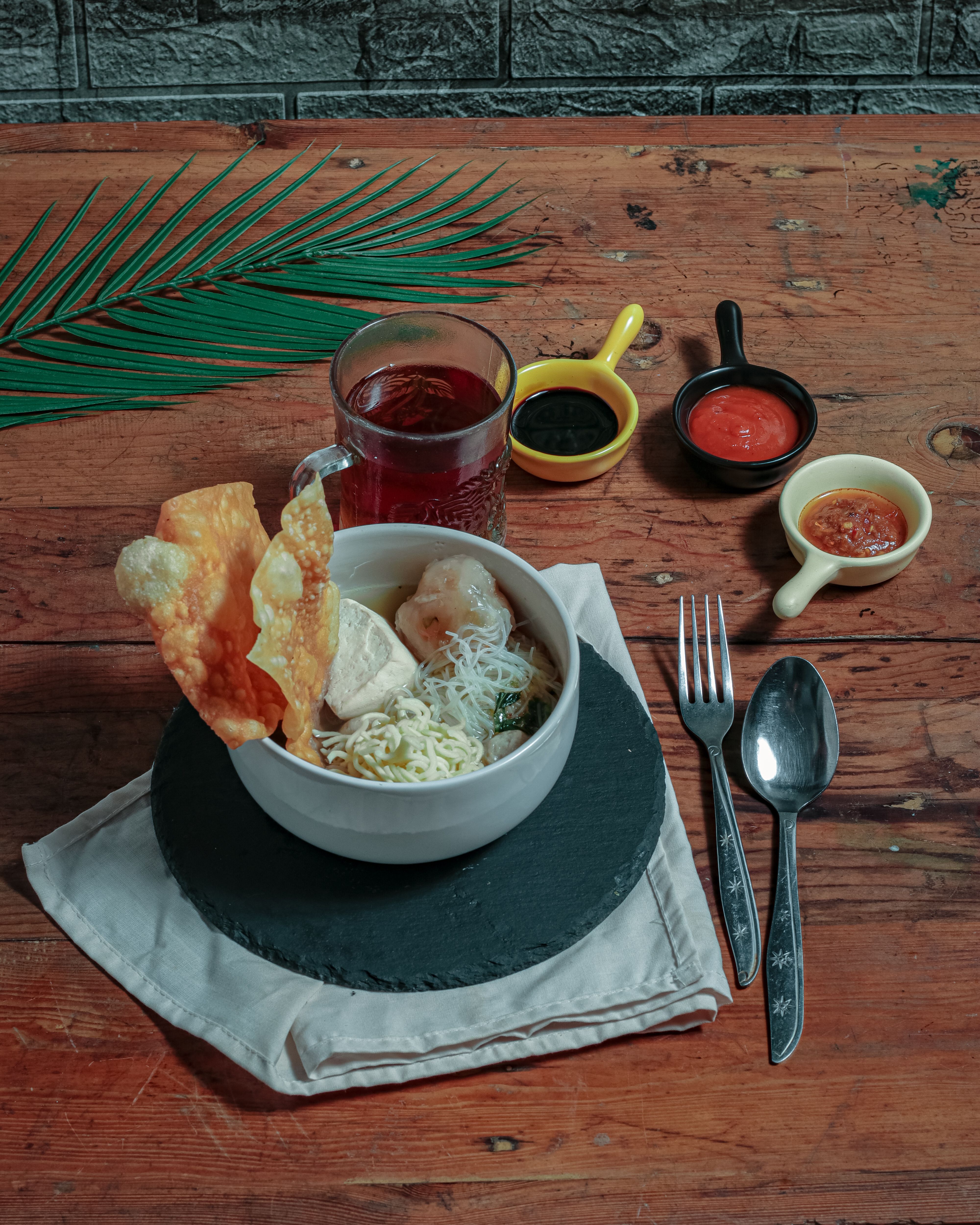 Delicious bowl of Mie Ayam with wontons and sides, perfect for Indonesian culinary exploration.