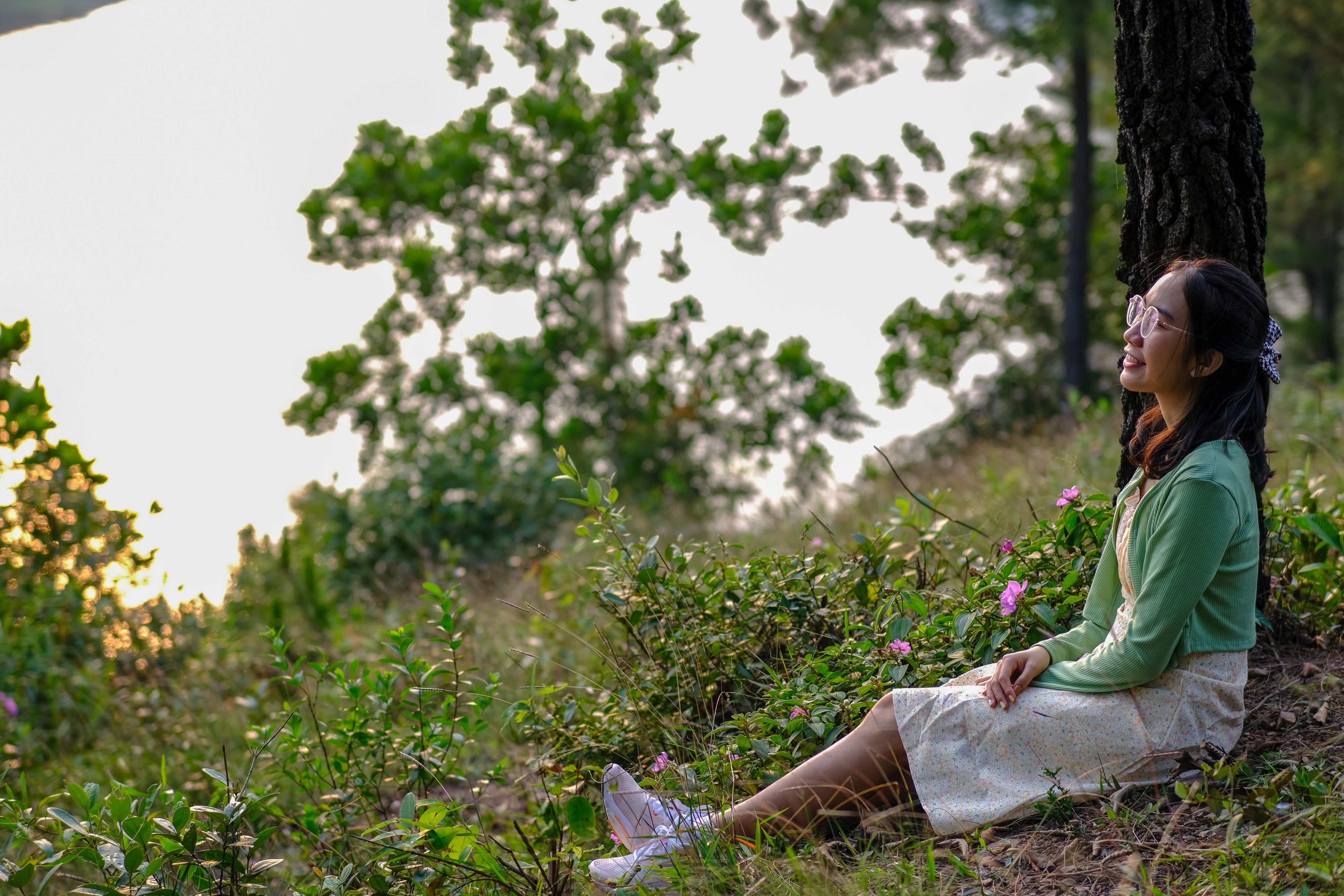 Smiling woman enjoys nature\'s tranquility in Hue, Vietnam, under the gentle evening light.