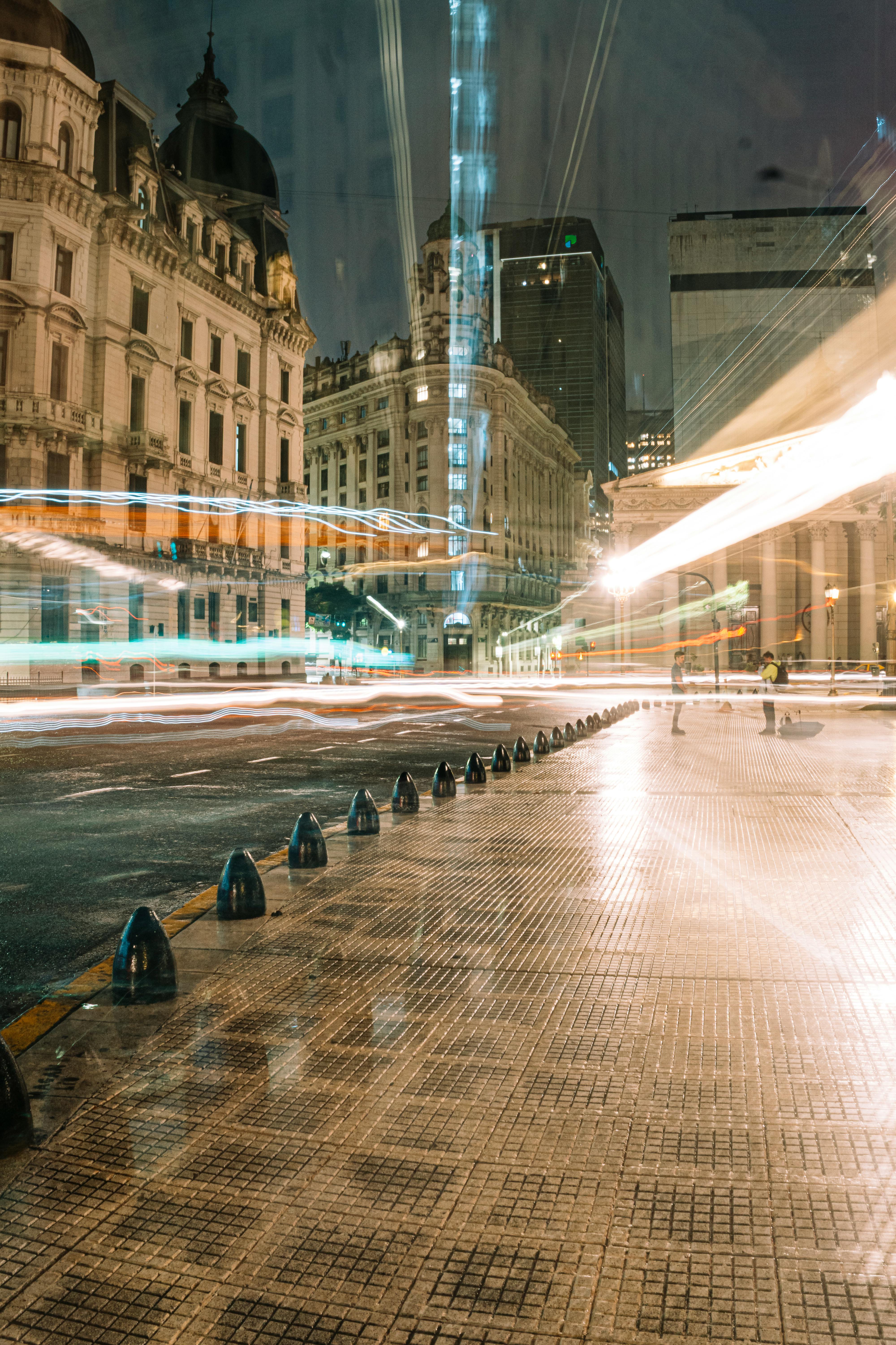 Dramatic long exposure photo capturing the bustling night streets of Buenos Aires with light trails and iconic architecture.