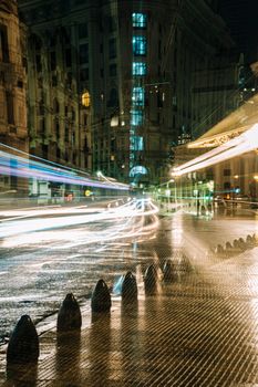 A vibrant long exposure photograph of a bustling Buenos Aires street at night, capturing streaks of light.