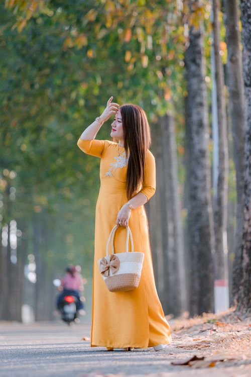 Elegant Woman in Yellow Dress Walking Outdoors · Free Stock Photo