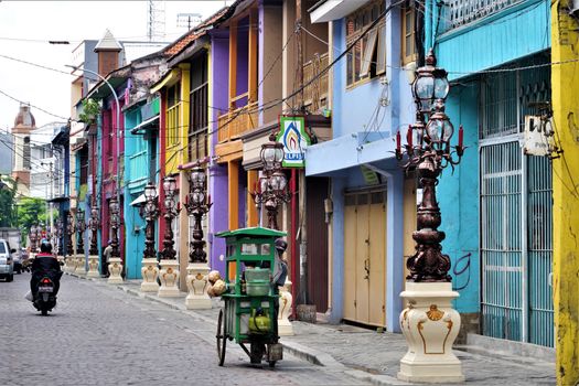 Vibrant street scene featuring colorful colonial buildings and antique street lamps.