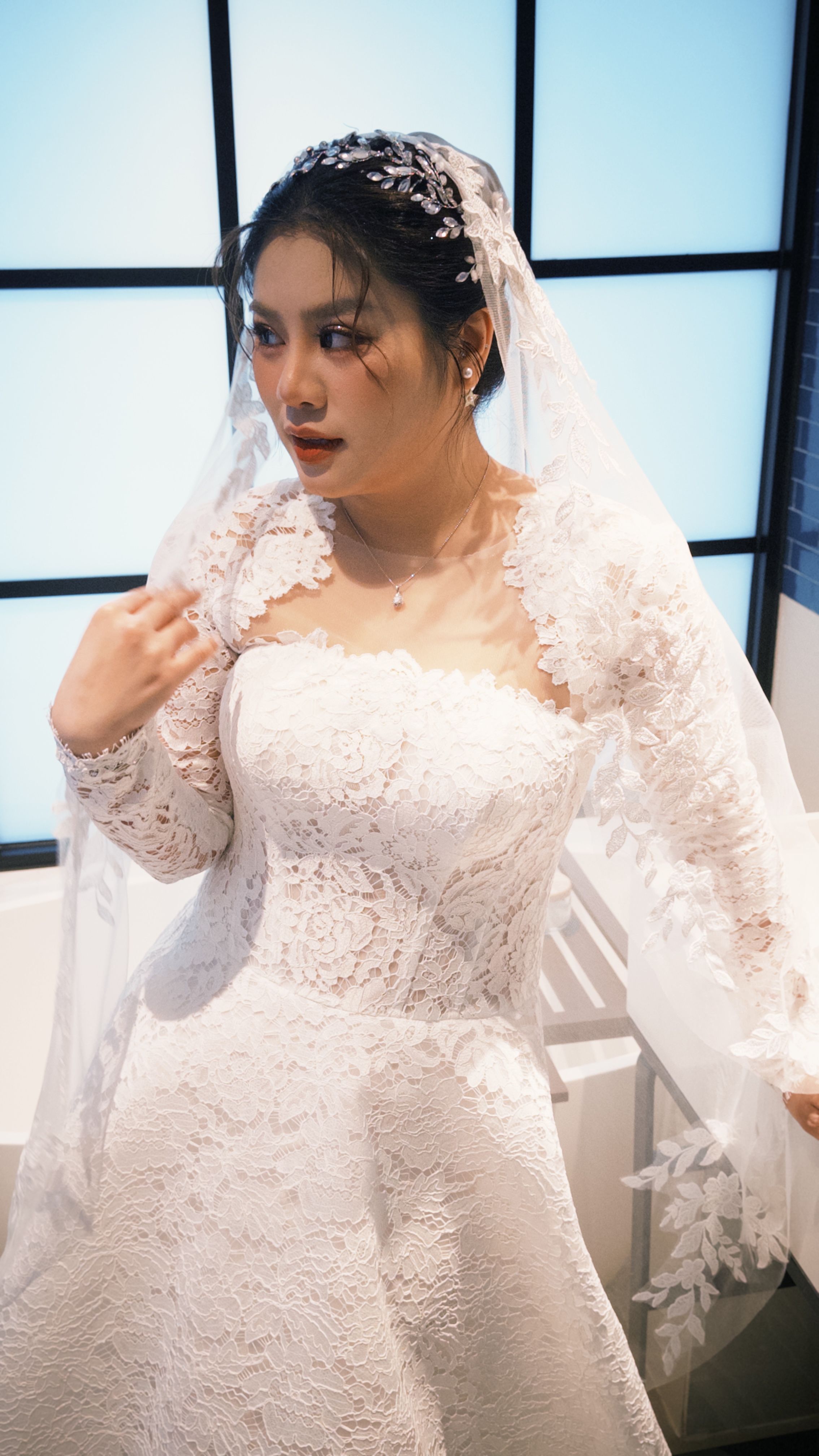Beautiful Vietnamese bride in a white ao dai, captured indoors. Perfect for wedding-themed content.