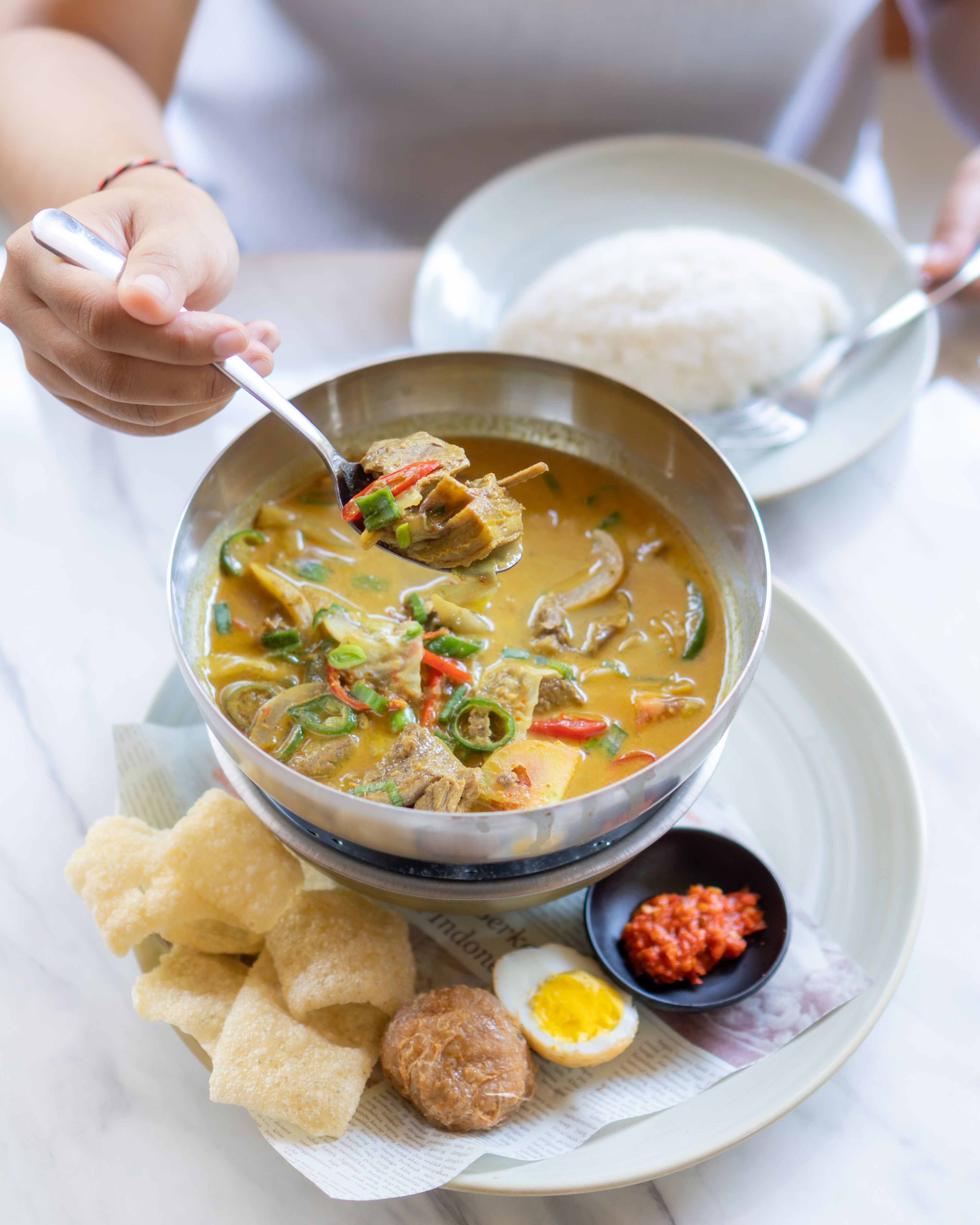 Delicious Sayur Lodeh served with rice and condiments in Bali, Indonesia.