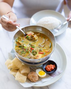 Delicious Sayur Lodeh served with rice and condiments in Bali, Indonesia.