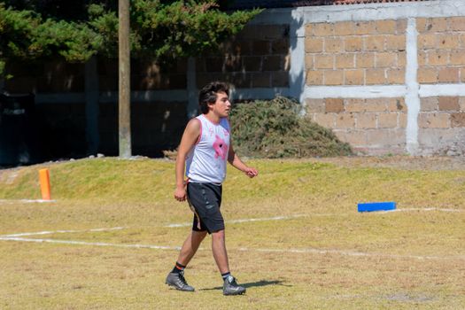 Young player enjoying a sunny day outdoors playing football in Toluca, Mexico.