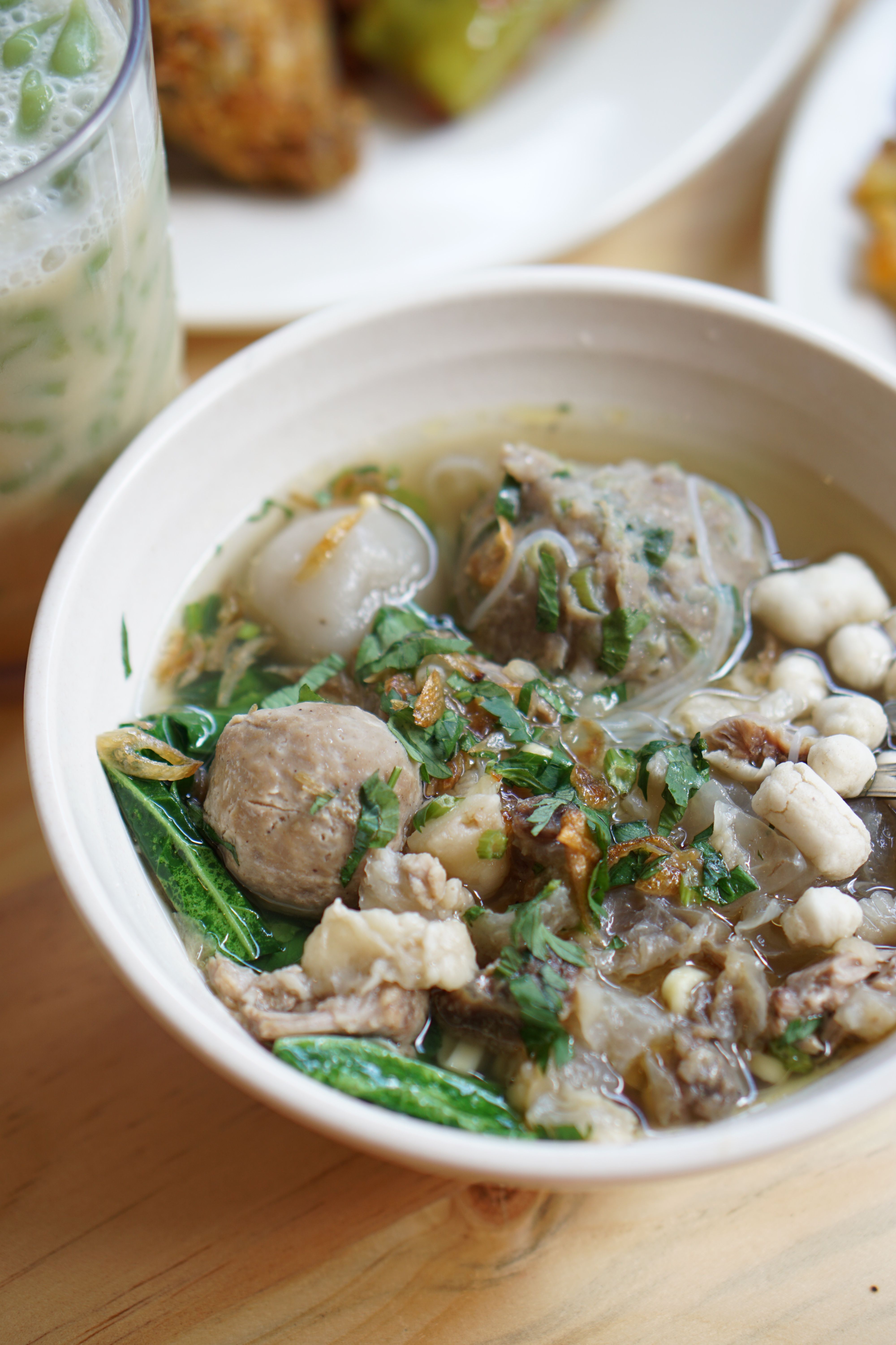 A bowl of traditional Indonesian Bakso, featuring meatballs and vegetables, captured in Bali.