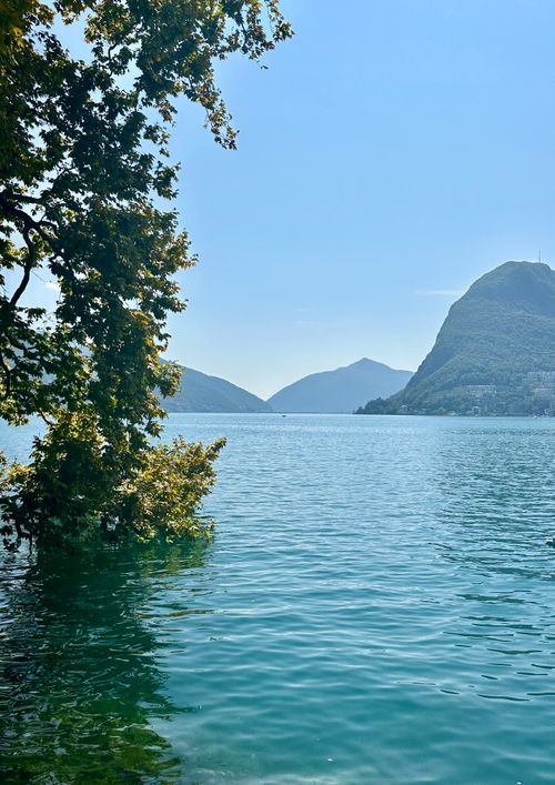 Free Peaceful scene of Lake Lugano with mountains and lush greenery, perfect for travel inspiration. Stock Photo