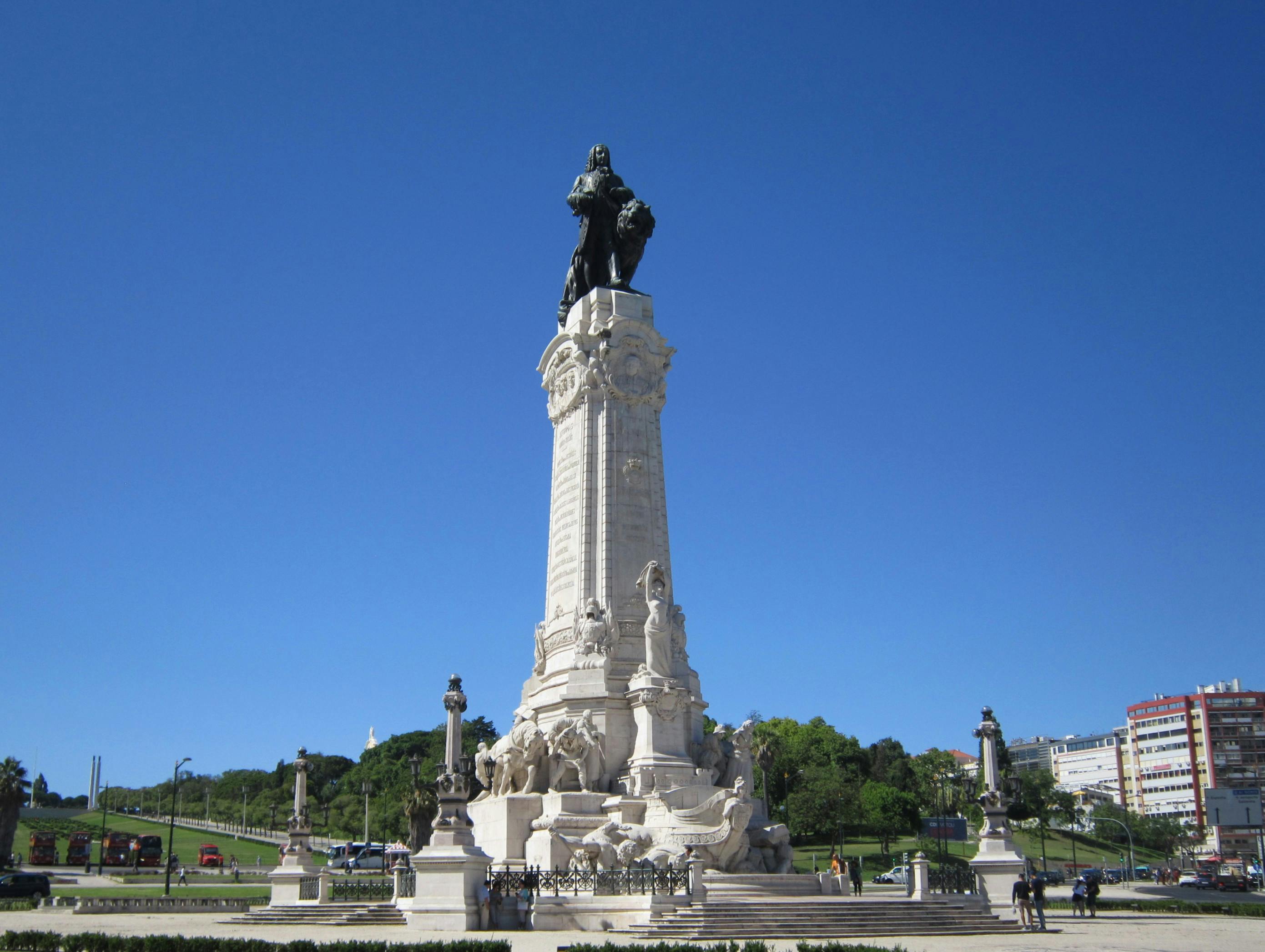 Impressive landmark statue of the Marquis of Pombal in Lisbon against a clear blue sky.