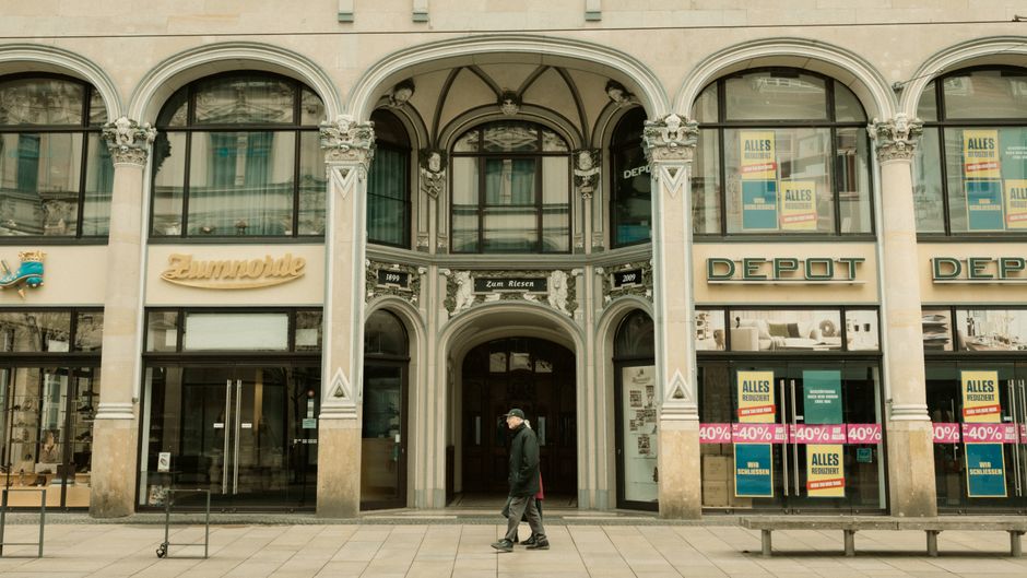 Beste Branchenverzeichnisse Deutschland: Top 10 Liste 2 A city scene showing a historic European building with shops and a pedestrian.