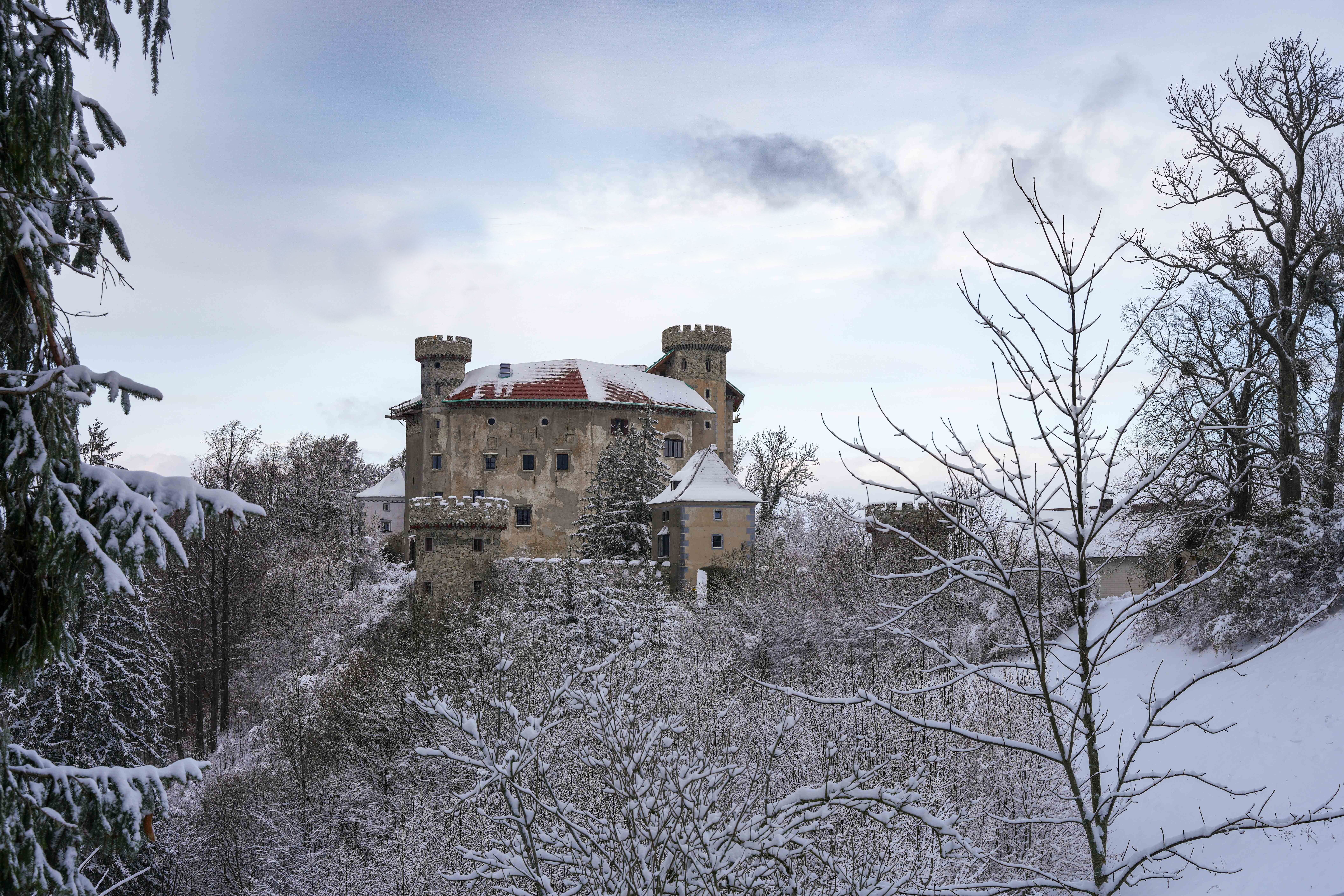Snow-covered stone castle surrounded by frosty trees in winter, an illustrative photo for the frozen, long-abandoned north of Norgan in Dragon's Dogma 2: Dark Arisen