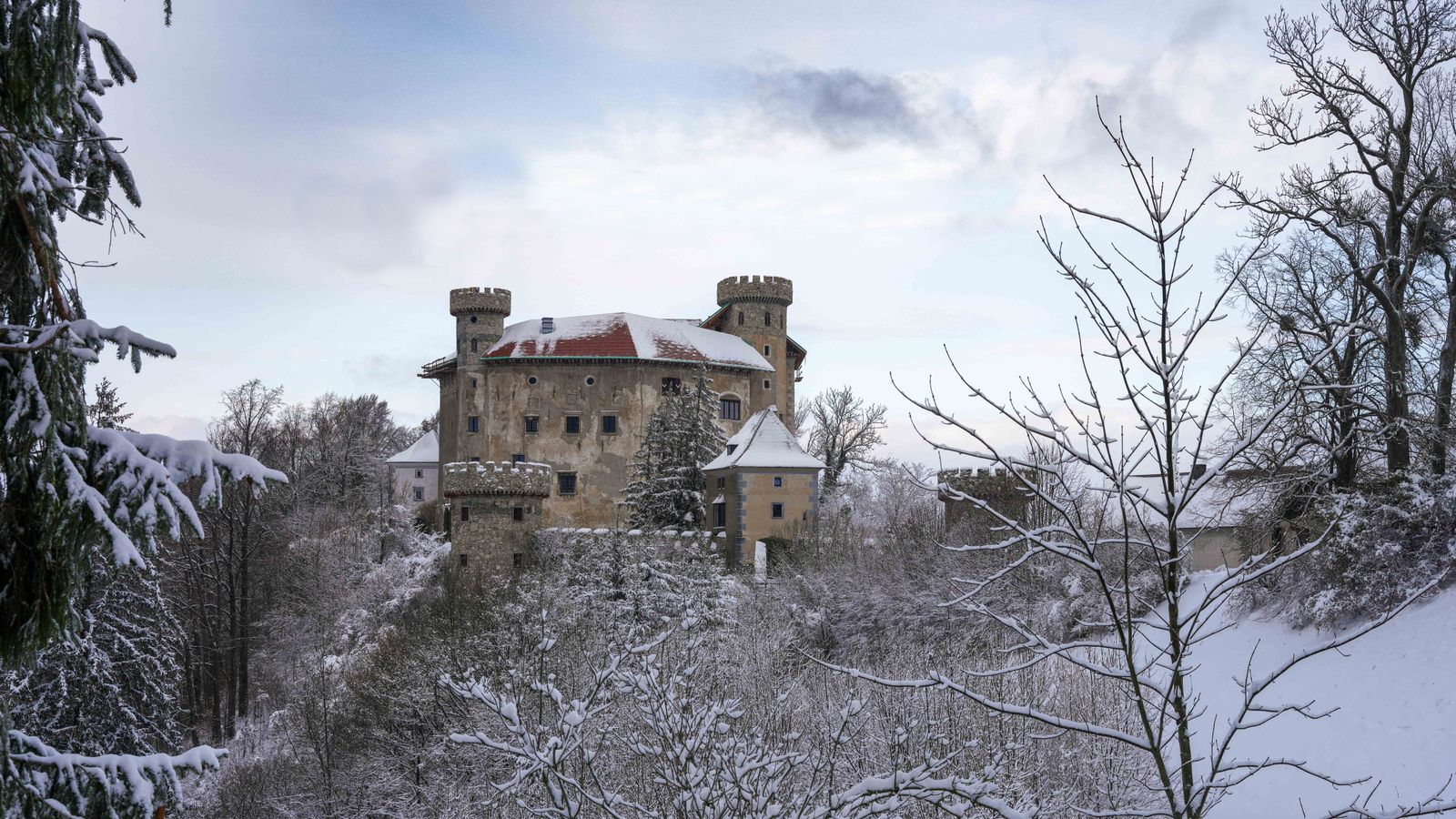 Snow-covered stone castle surrounded by frosty trees in winter, an illustrative photo for the frozen, long-abandoned north of Norgan in Dragon's Dogma 2: Dark Arisen