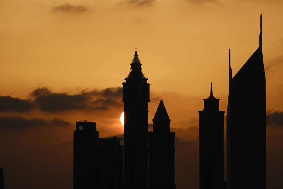 Diverse country pavilions and vibrant lights at Global Village Dubai at sunset