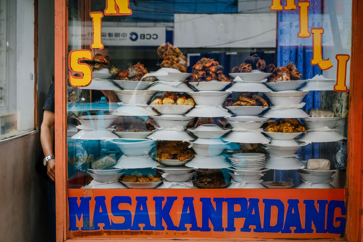 A colorful display of Padang dishes stacked side by side, in the style of a classic Padang restaurant window