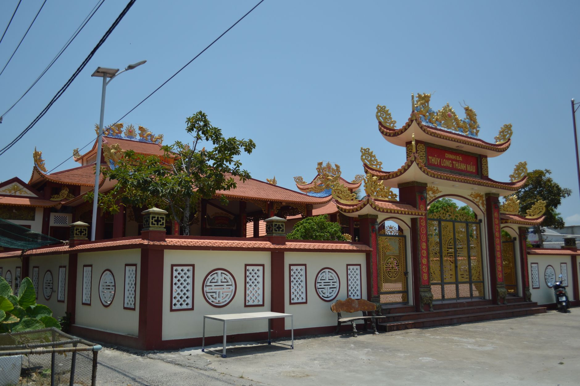 A decorative Asian temple with a traditional ornate gate under a clear blue sky, showcasing cultural architecture.