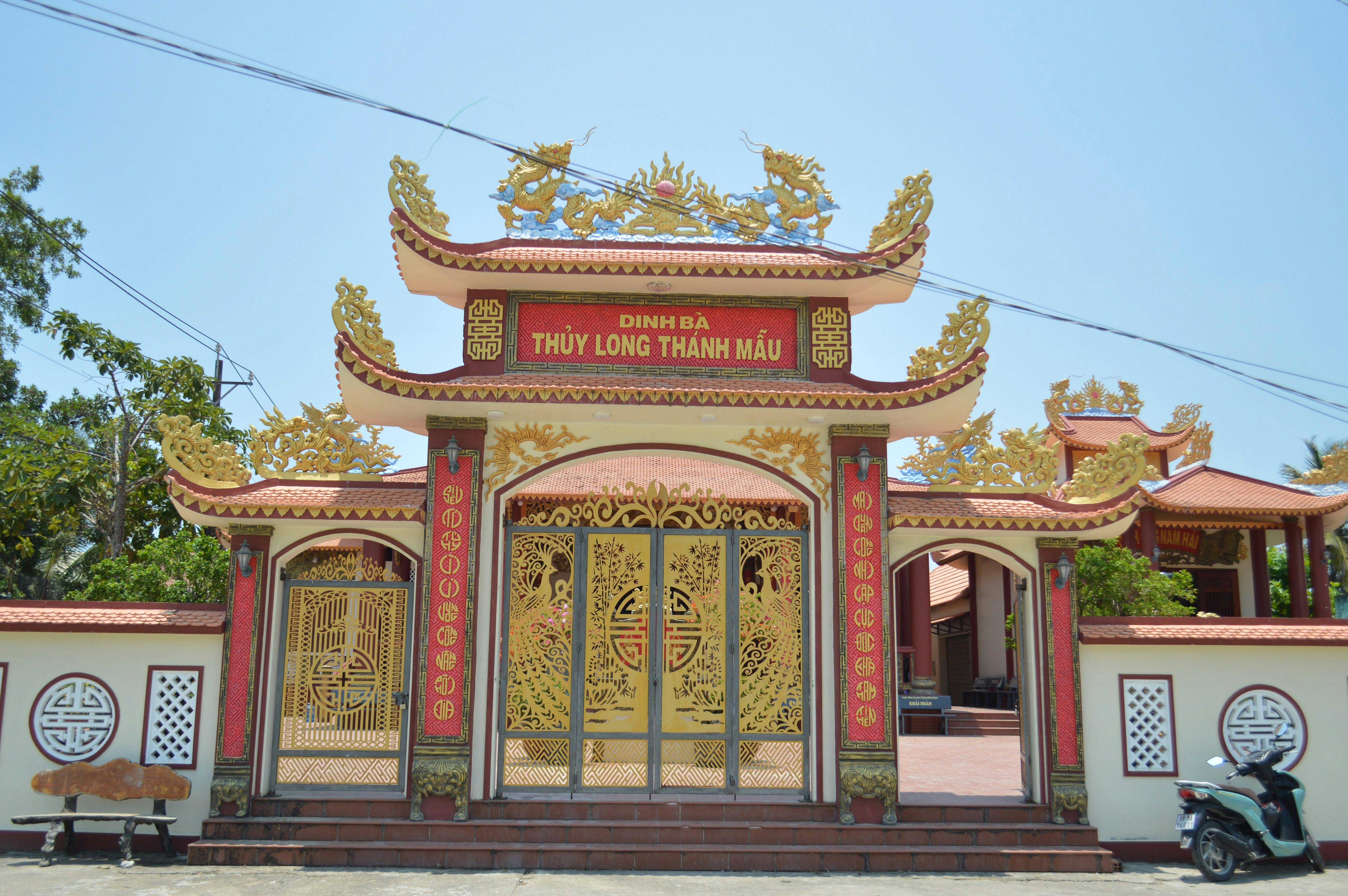An ornate Vietnamese temple gate with dragon motifs and traditional architecture.