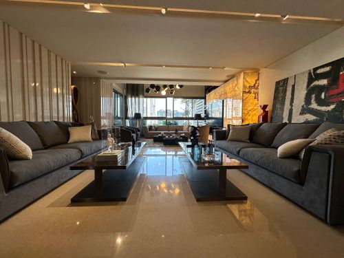 Free Spacious modern living room featuring elegant decor, large sofas, and a city view through a window. Stock Photo