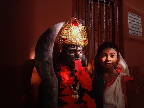 Free A young woman poses with a Kali idol during a Hindu festival in Kolkata, India. Stock Photo