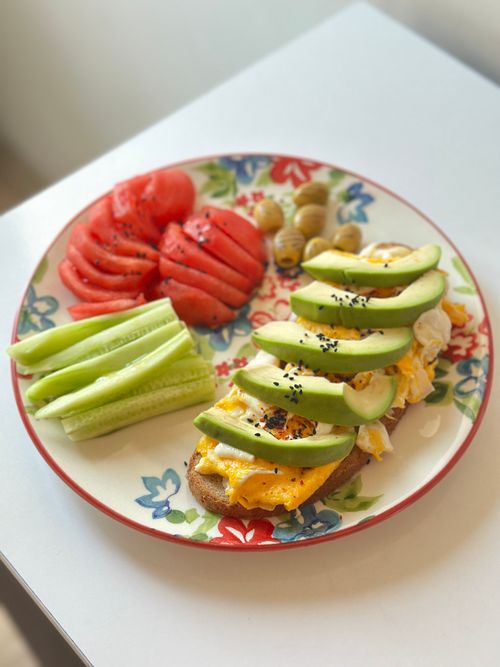 Free A colorful plate of avocado toast, tomatoes, cucumbers, and olives, ideal for a healthy breakfast. Stock Photo