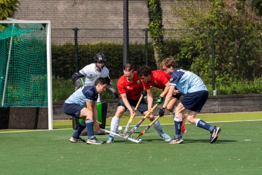 Exciting field hockey game with players in action, showcasing teamwork and competition.
