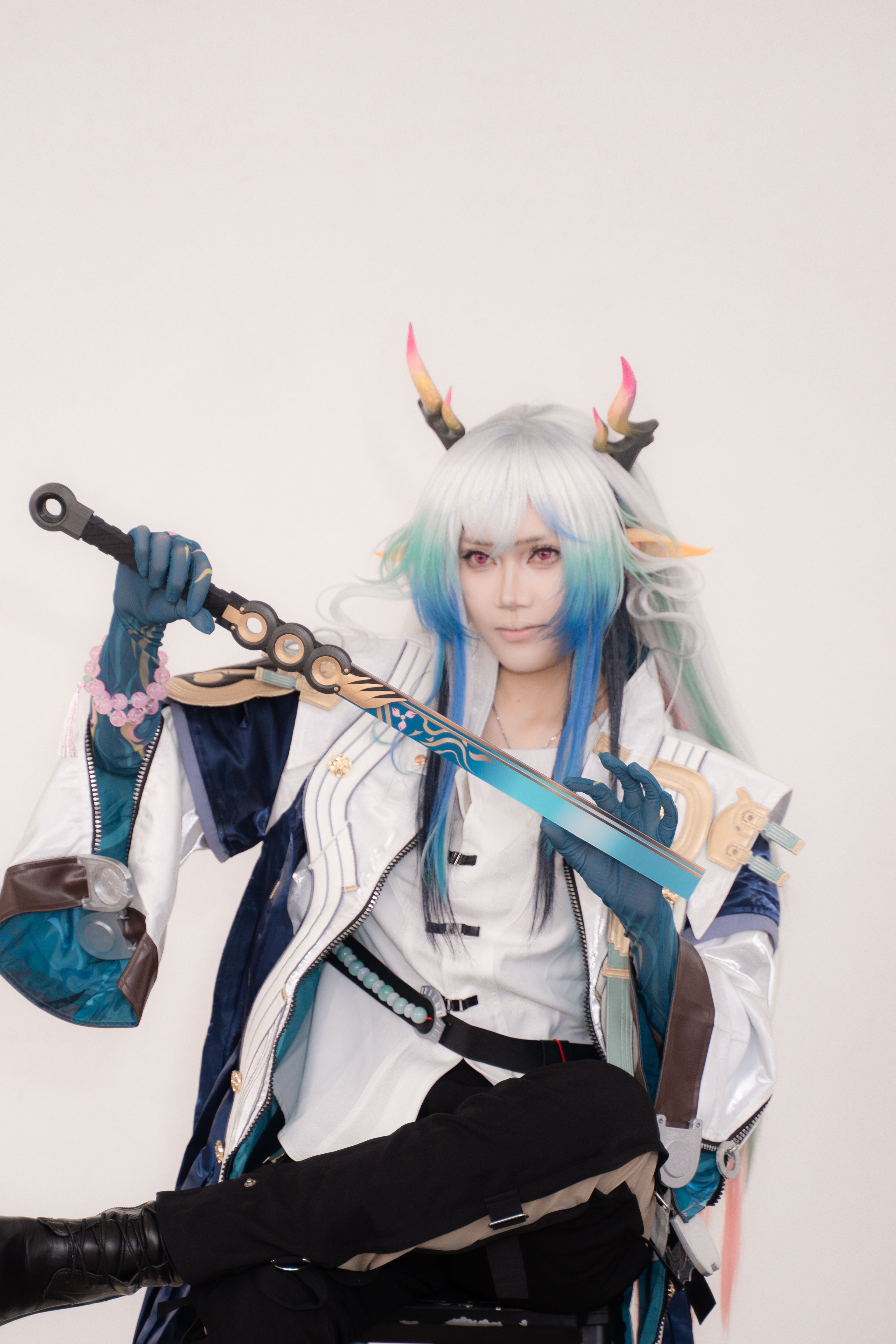 Striking cosplay featuring colorful hair and detailed costume weaponry.