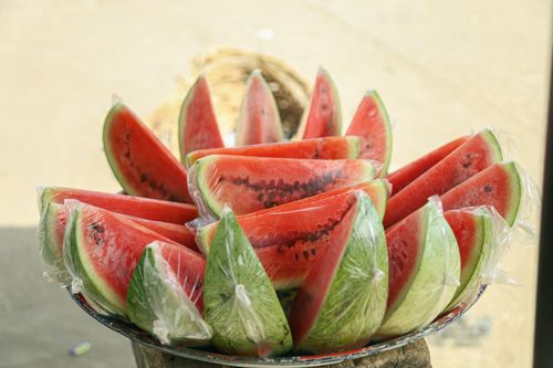 Free A vibrant display of fresh watermelon slices wrapped in plastic, perfect for a refreshing snack. Stock Photo