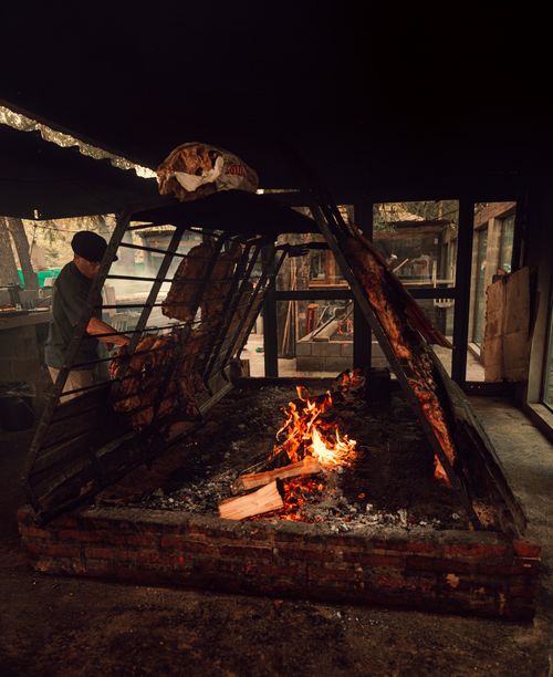 Free Authentic Argentine asado barbecue being cooked over an open flame in Uribelarrea, Argentina. Stock Photo