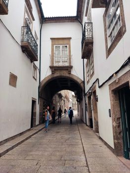 Pedestrian street under an archway in historic Guimarães, Portugal.