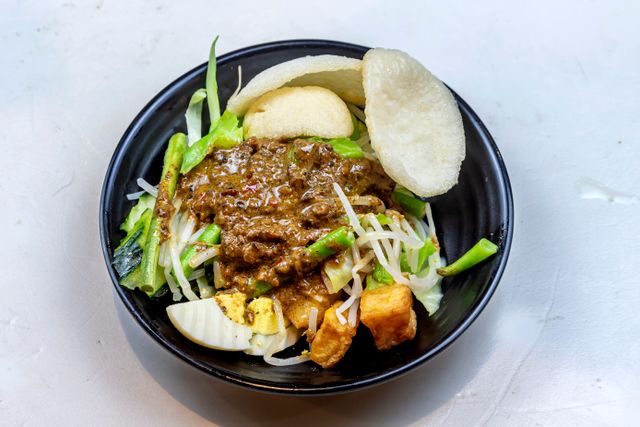 A vibrant Indonesian Gado-Gado dish featuring vegetables, tofu, and rich peanut sauce.