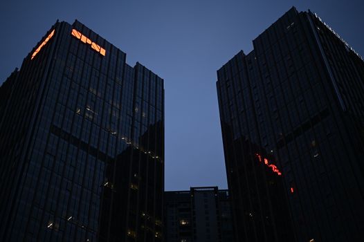 Tall buildings against a twilight sky, showcasing urban architecture and city lights.
