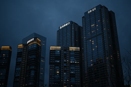 Night view of modern skyscrapers illuminated against a dark sky, enhancing city nightlife vibes.