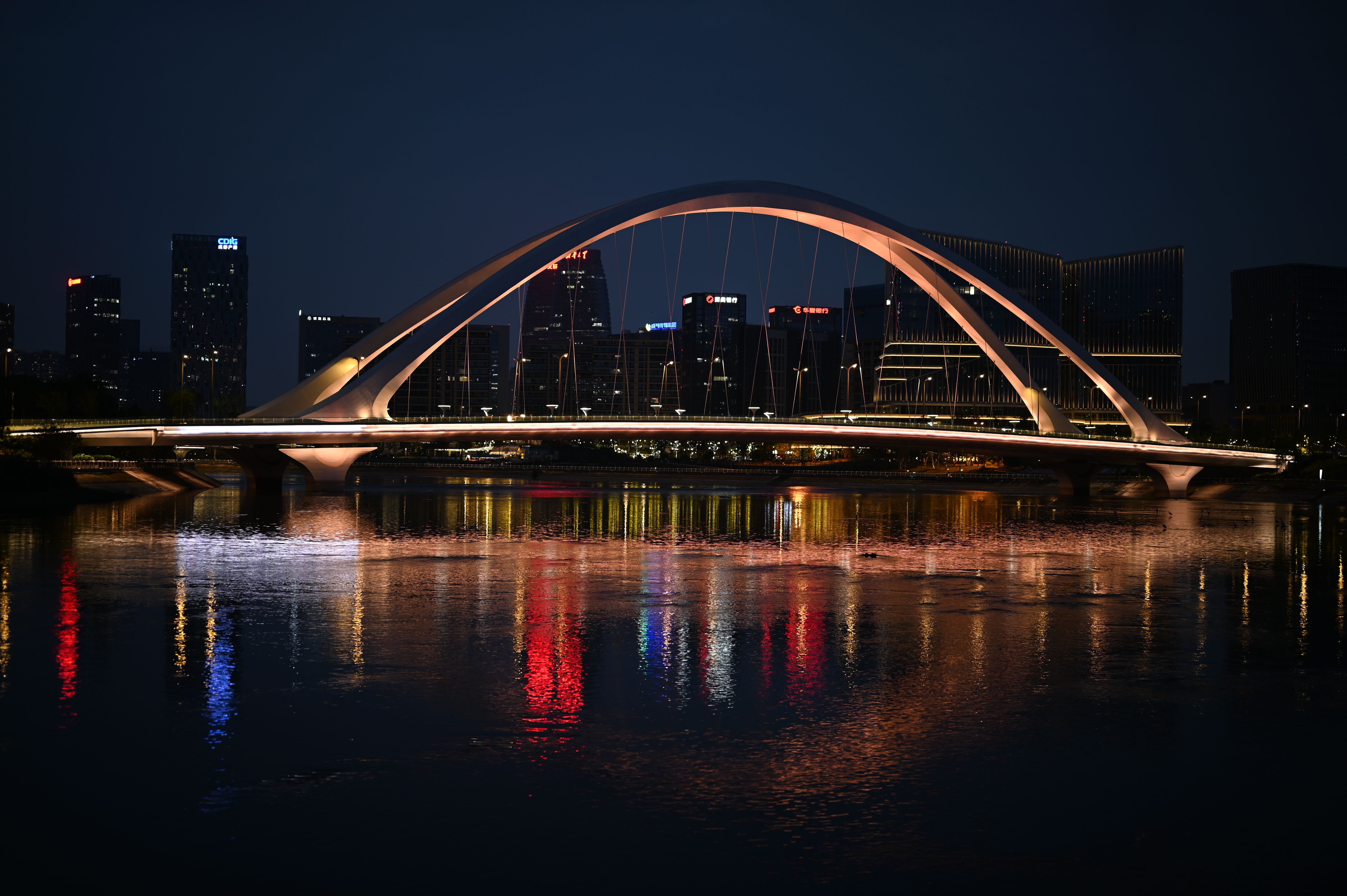 Illuminated Bridge Over Calm Water at Night · Free Stock Photo