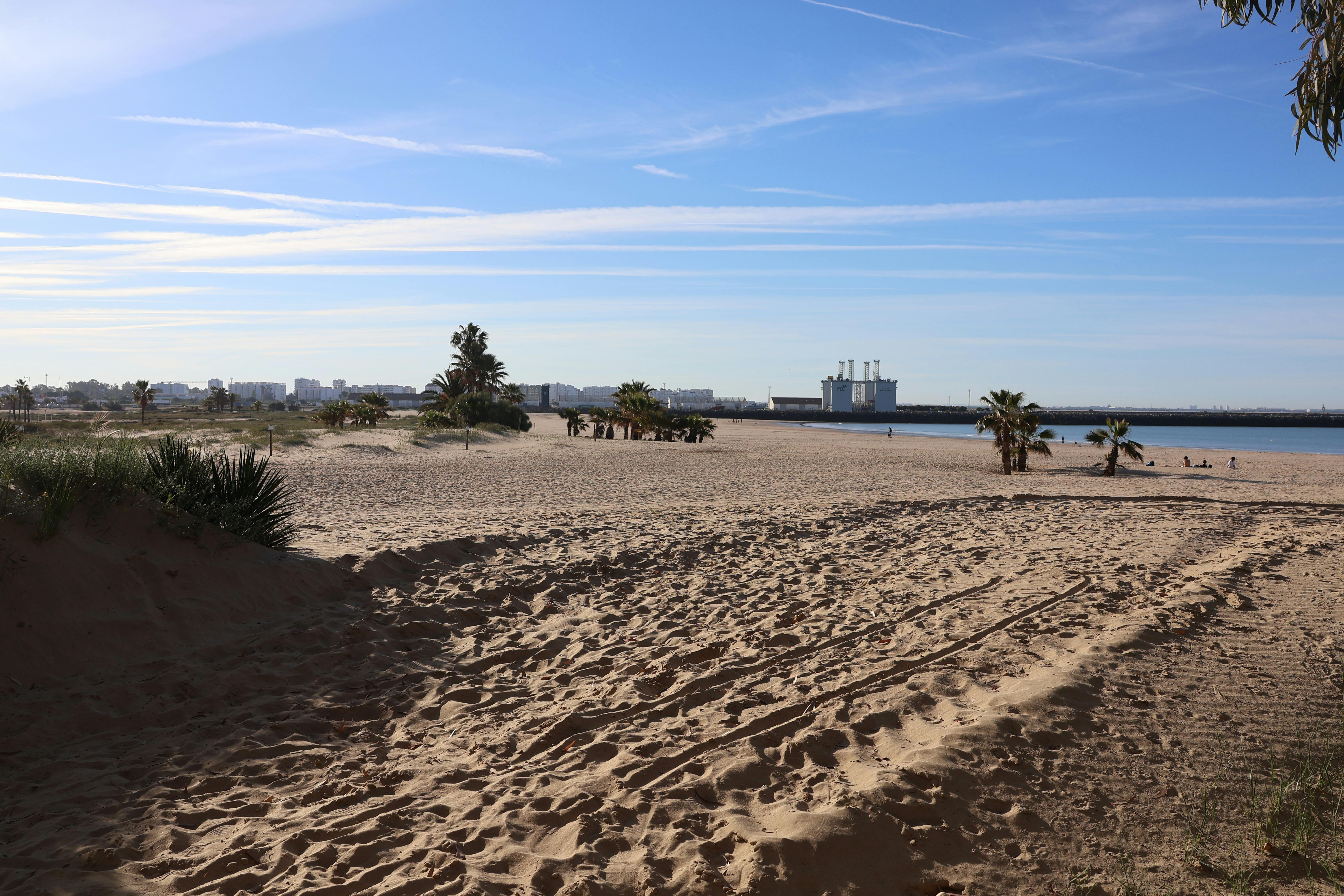 A tranquil beach scene in El Puerto de Santa María, capturing the warm sands and blue skies.