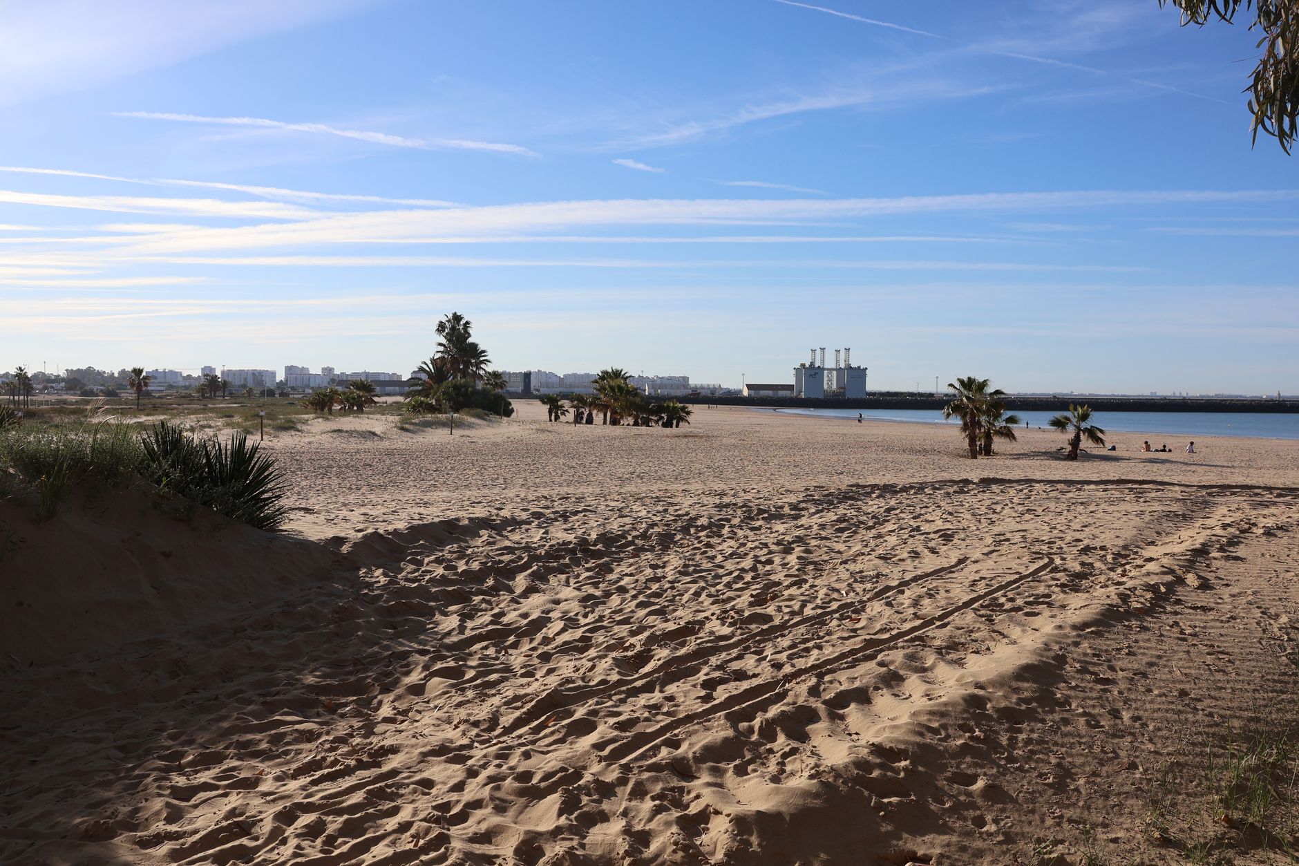 A tranquil beach scene in El Puerto de Santa María, capturing the warm sands and blue skies.