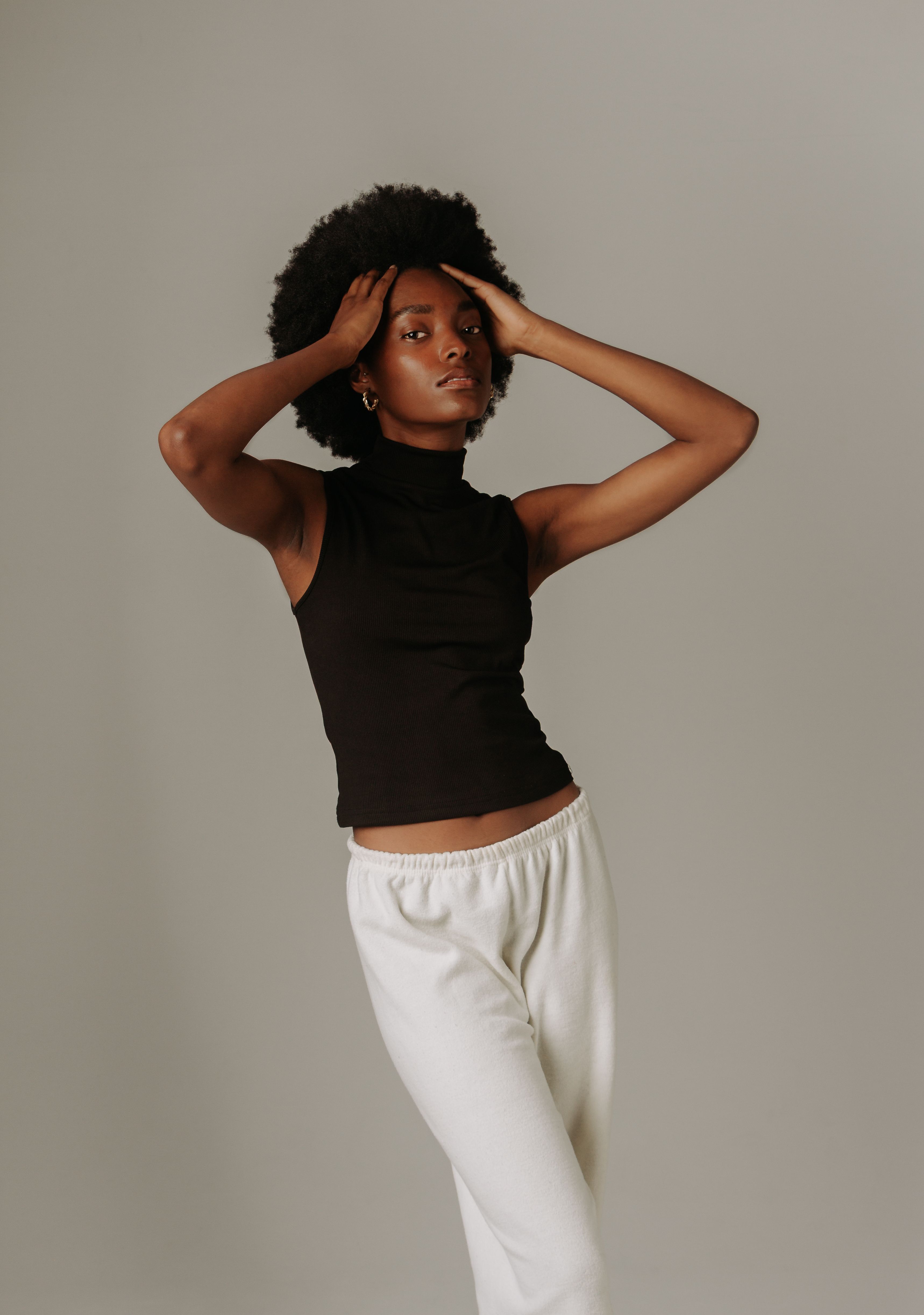 Stylish portrait of a woman posing confidently against a studio backdrop.