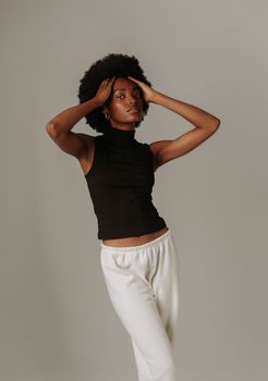Stylish portrait of a woman posing confidently against a studio backdrop.
