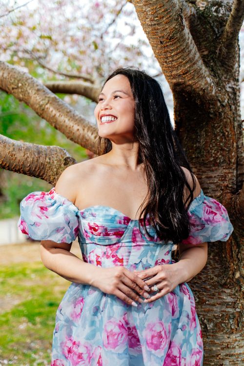 Smiling Woman in Floral Dress under Cherry Blossoms · Free Stock Photo