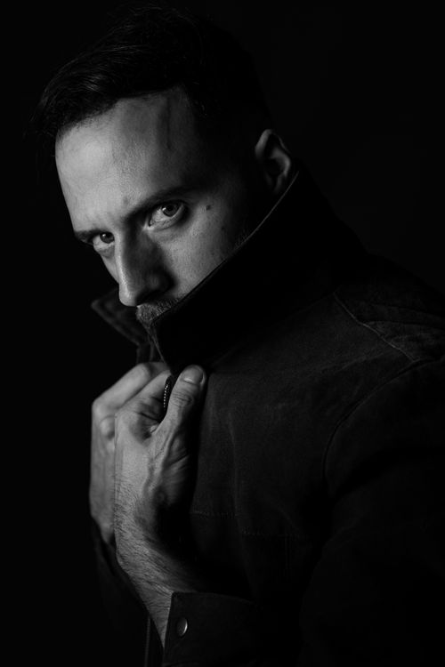 Free Intense black and white portrait of a man in a dark jacket, looking mysterious. Stock Photo