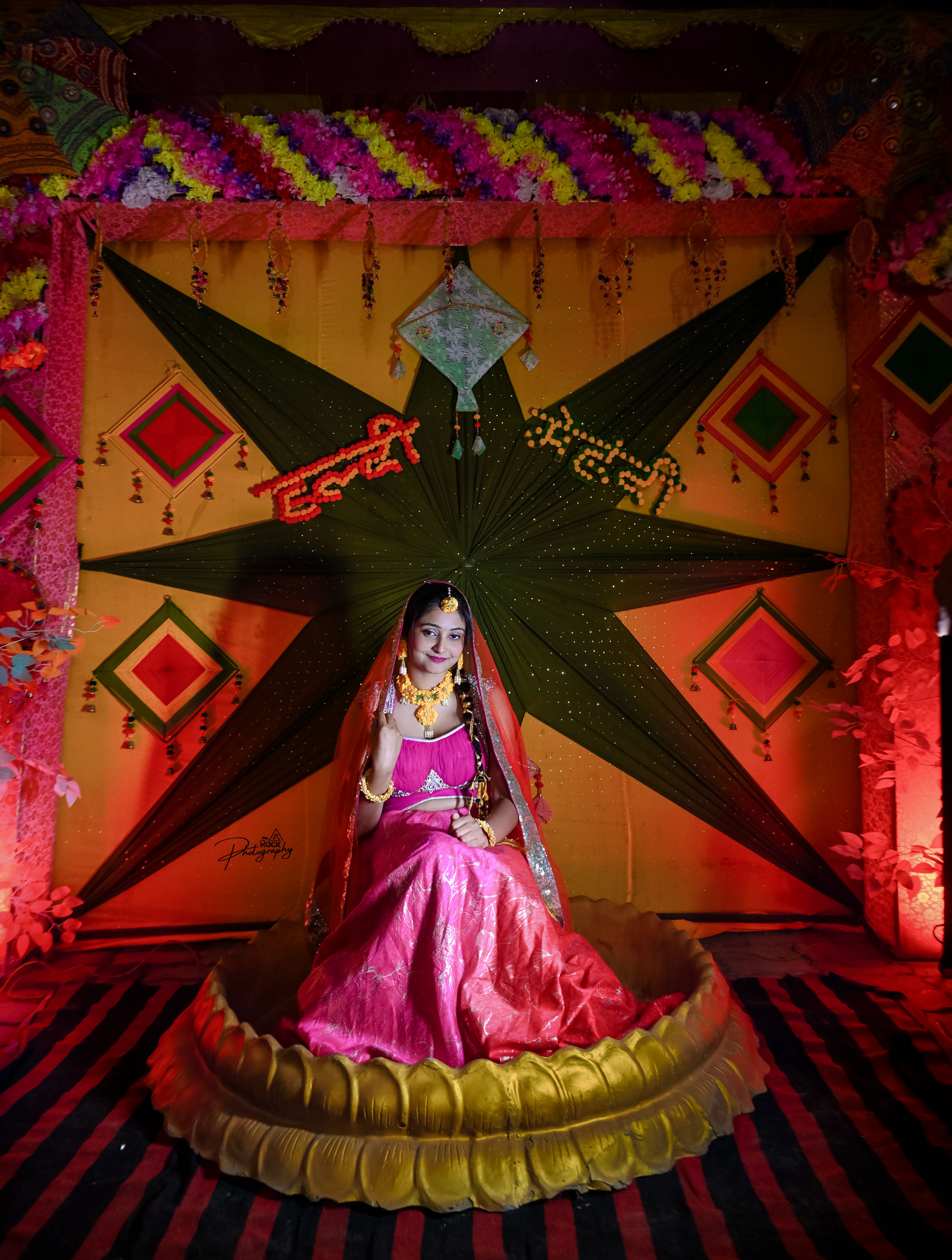 Elegant Indian bride in colorful attire against a decorative backdrop in Bihar, India.