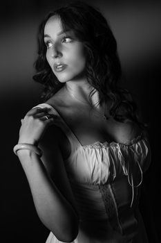 Elegant monochrome portrait showcasing a woman in a studio setting with dramatic lighting.
