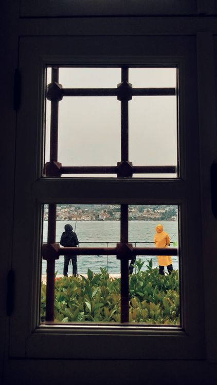 View of Two People by the Sea Through a Window · Free Stock Photo