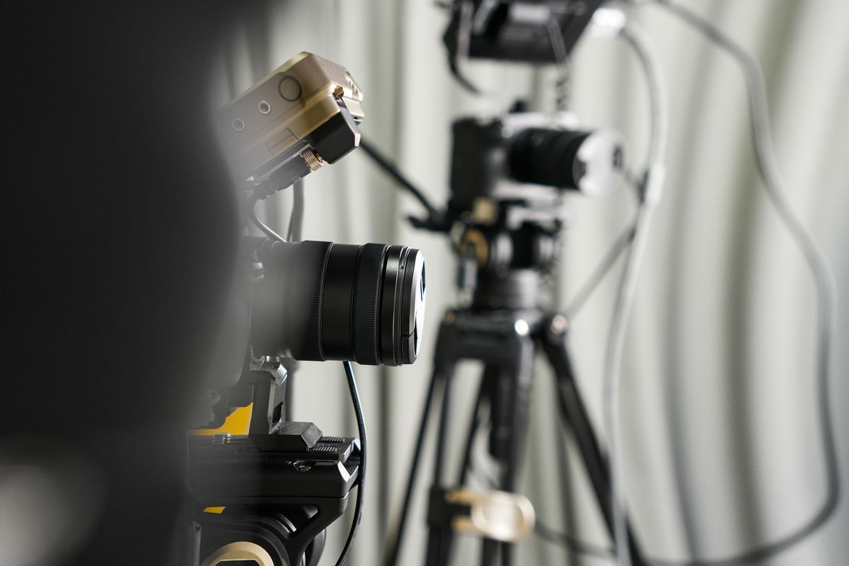 Close-up of professional video cameras and studio lighting rigged for a live broadcast, illustrative photo