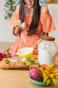 Woman in cheerful kitchen baking with flour, eggs, and fresh fruit. Perfect for home cooking themes.